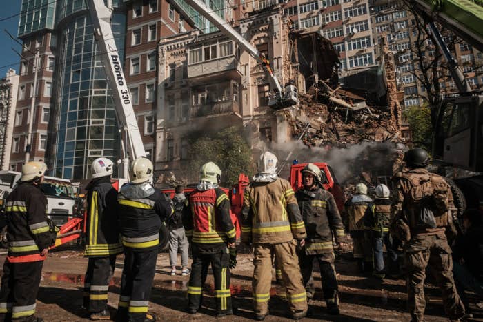 Ukrainian firefighters works on a destroyed building after a drone attack in Kyiv on October 17, 2022, amid the Russian invasion of Ukraine.