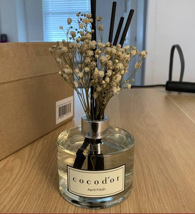 reviewer's reed diffuser with faux flowers in bottle