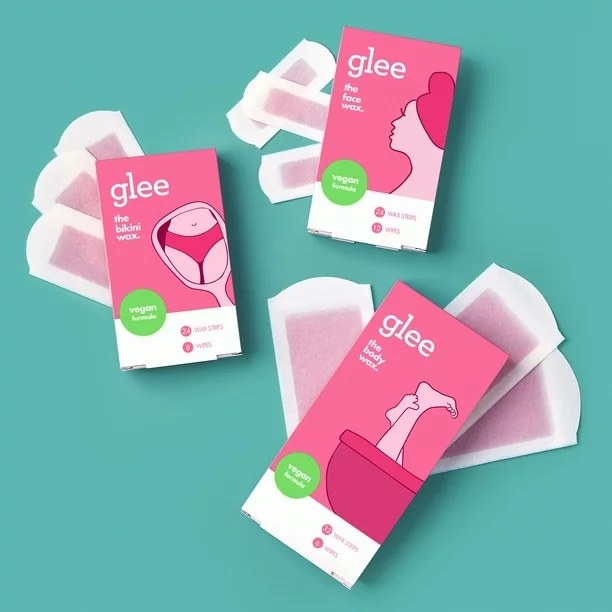 Three pink boxes of different types of wax strips with blue background