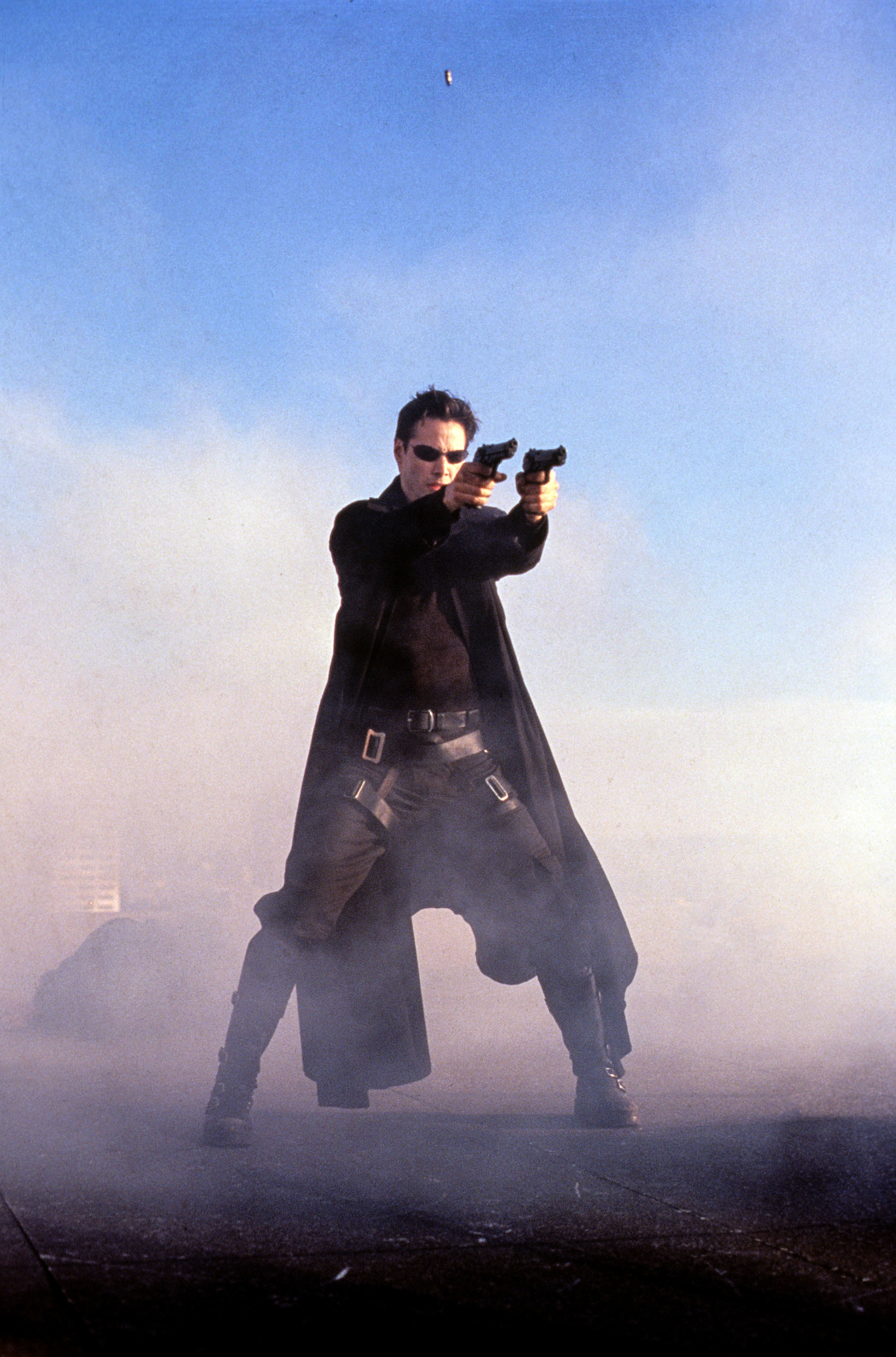 Keanu as Neo in The Matrix holding two guns