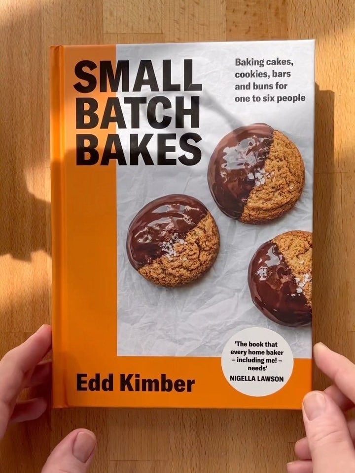 a person holding a copy of the book small batch bakes