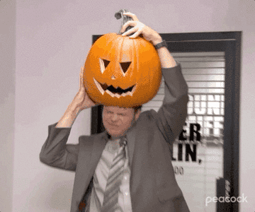 Dwight Schrute puts a pumpkin on his head