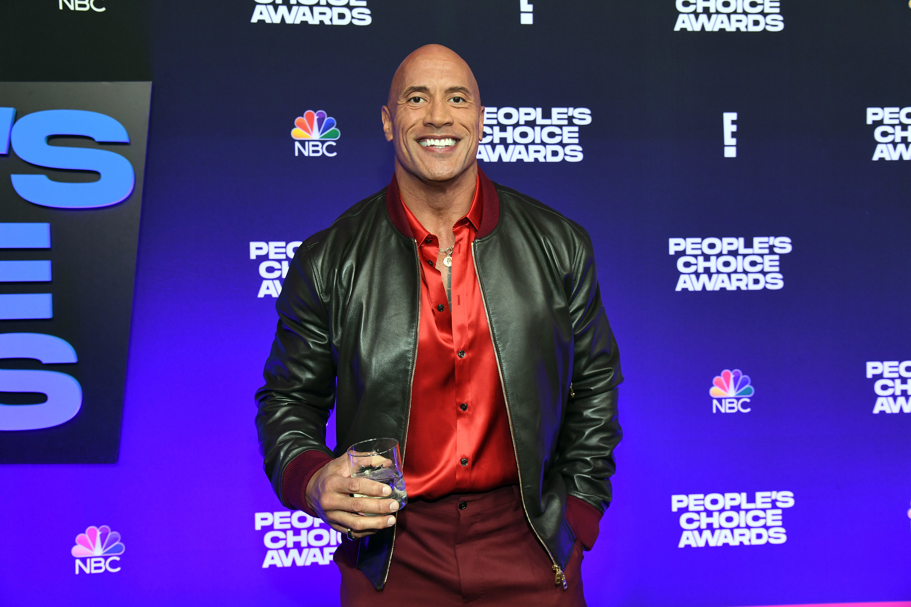 Dwayne at the People&#x27;s Choice Awards in a leather jacket and holding a glass