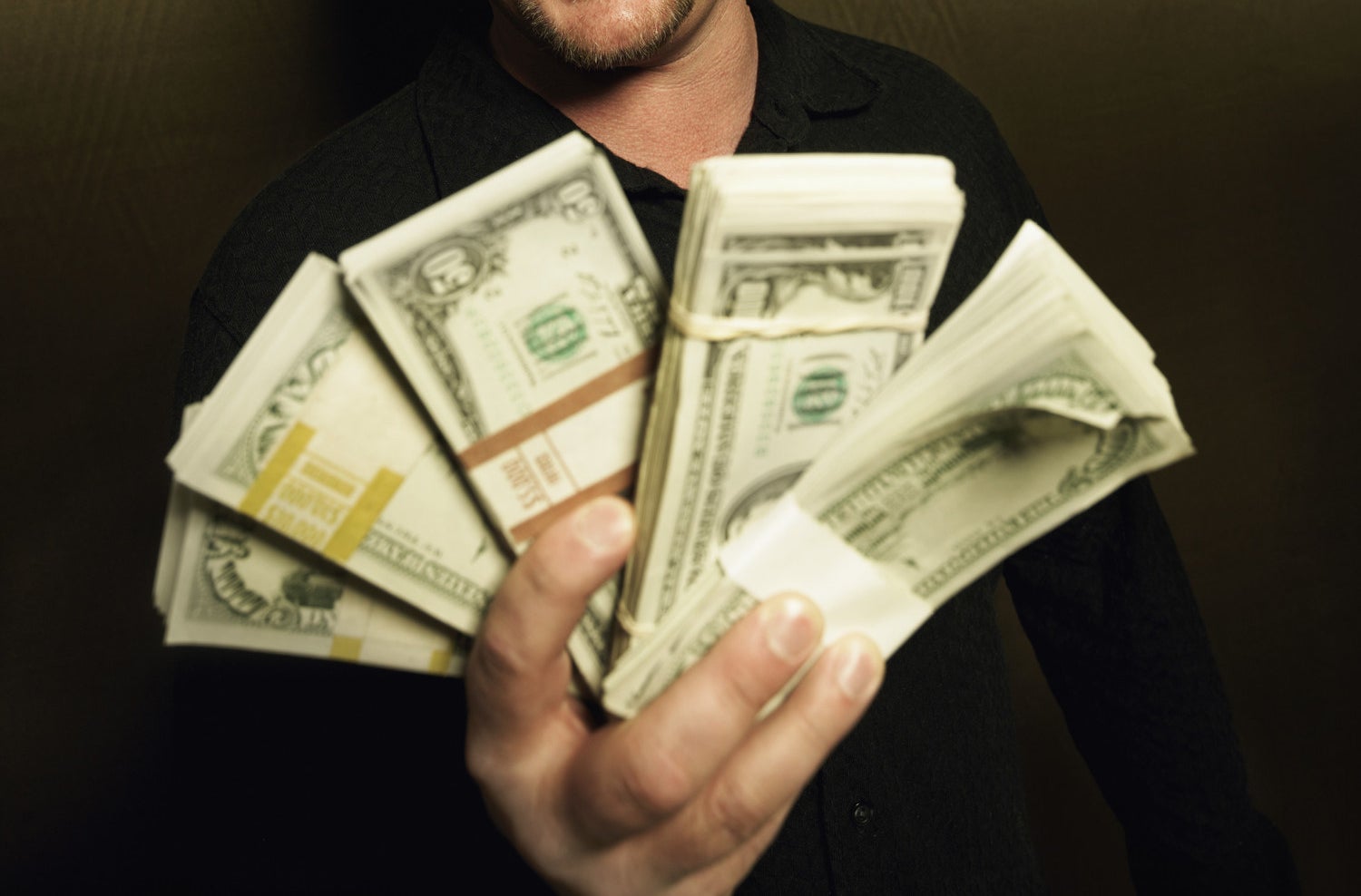 A man holding wads of cash