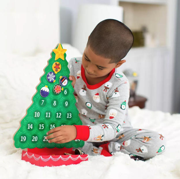 a tree-shaped wooden advent calendar and a child playing with it