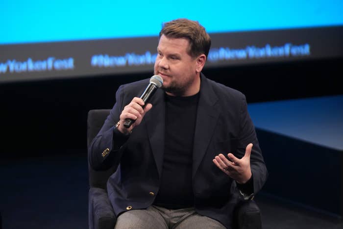 James sitting in a chair as he speaks onstage at an event