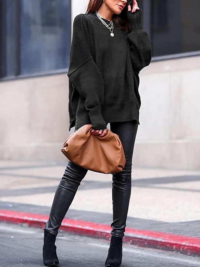 a person wearing the sweater with leather leggings