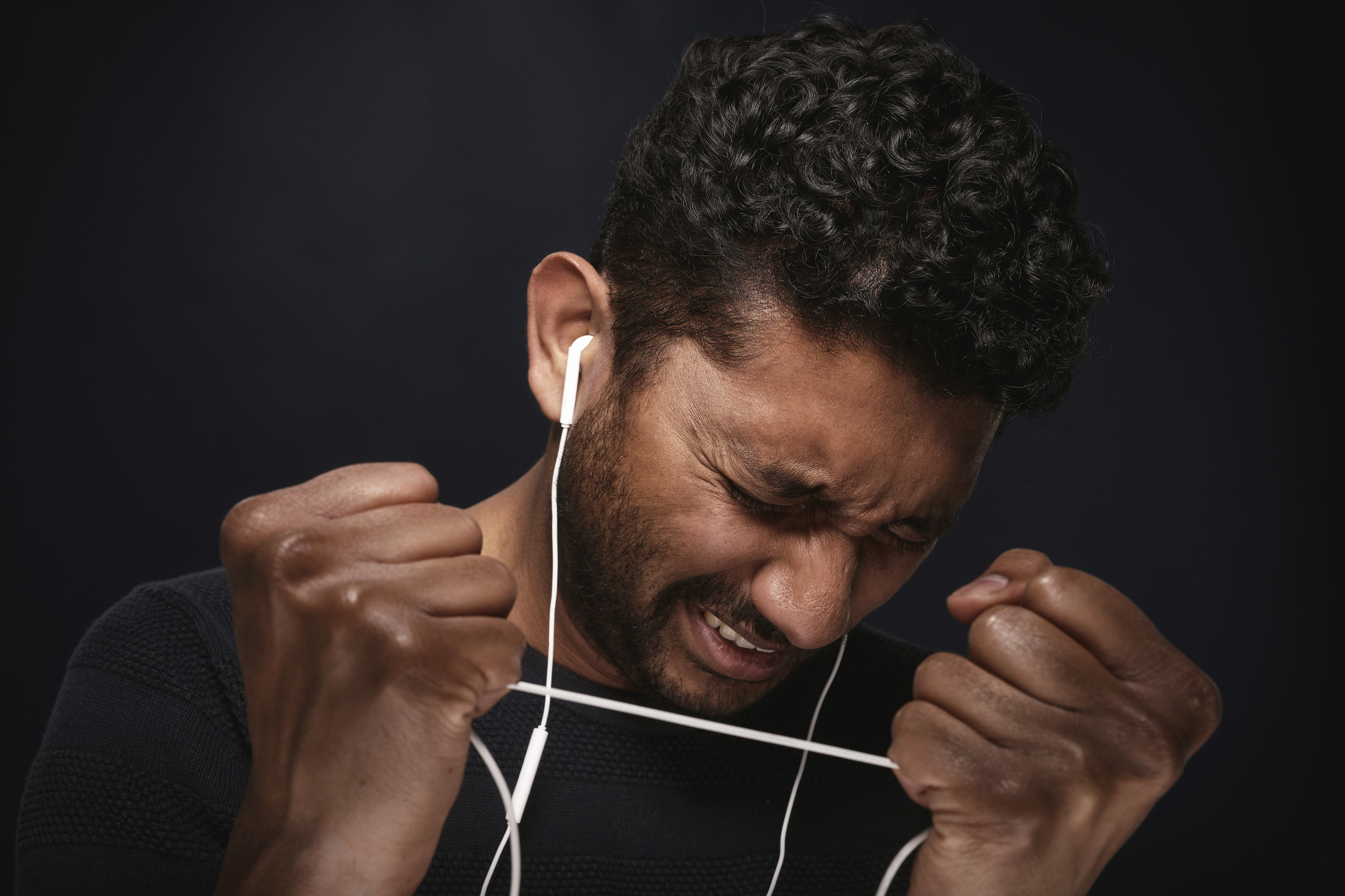 A man tearing at his headphones