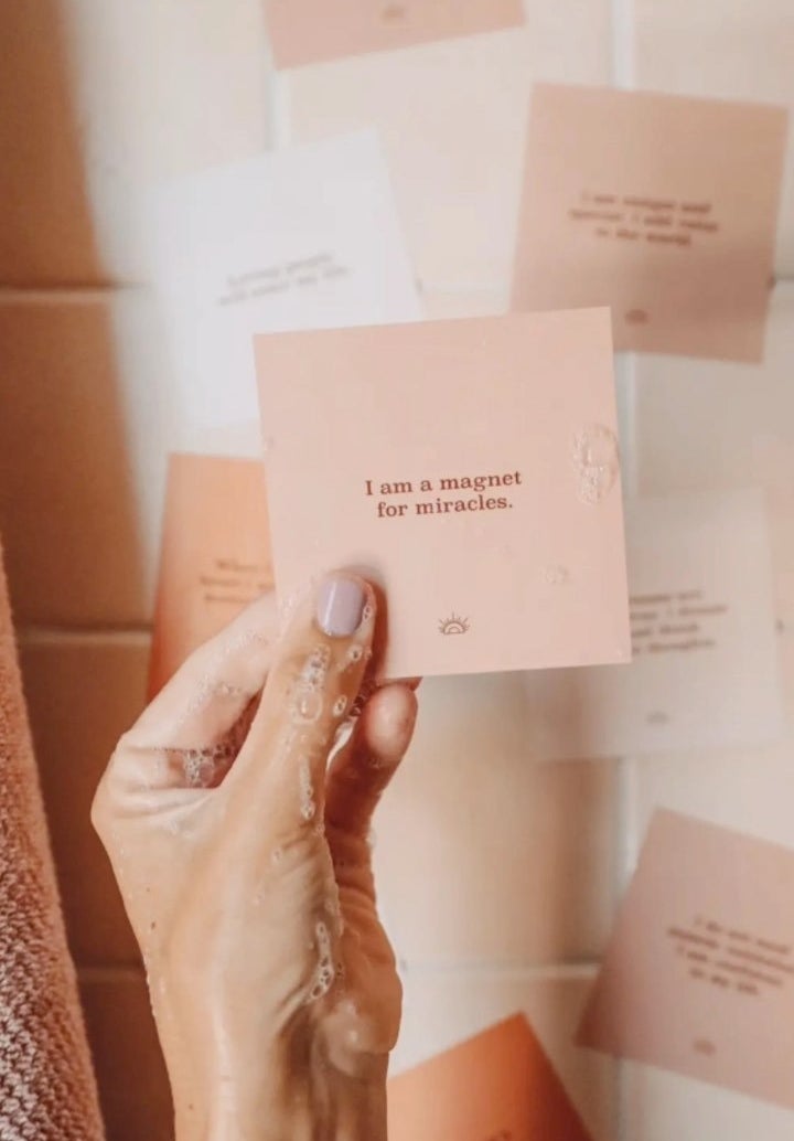 a person holding up one of the waterproof affirmation cards