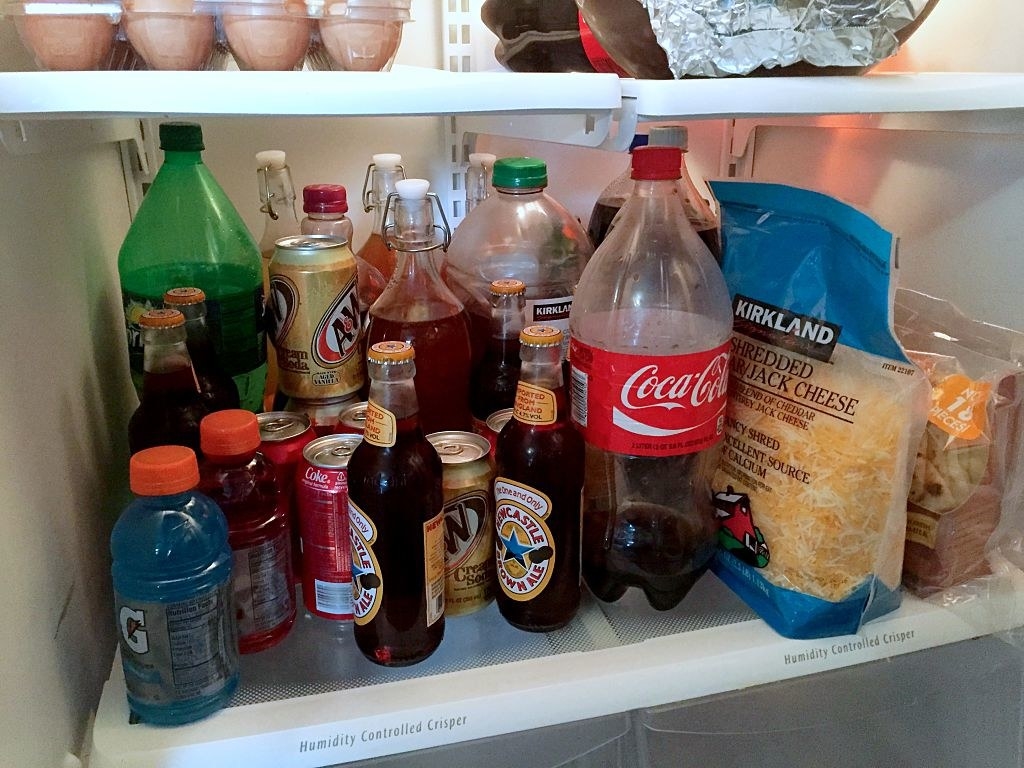 Interior of a home fridge showing several groceries, specially drinks