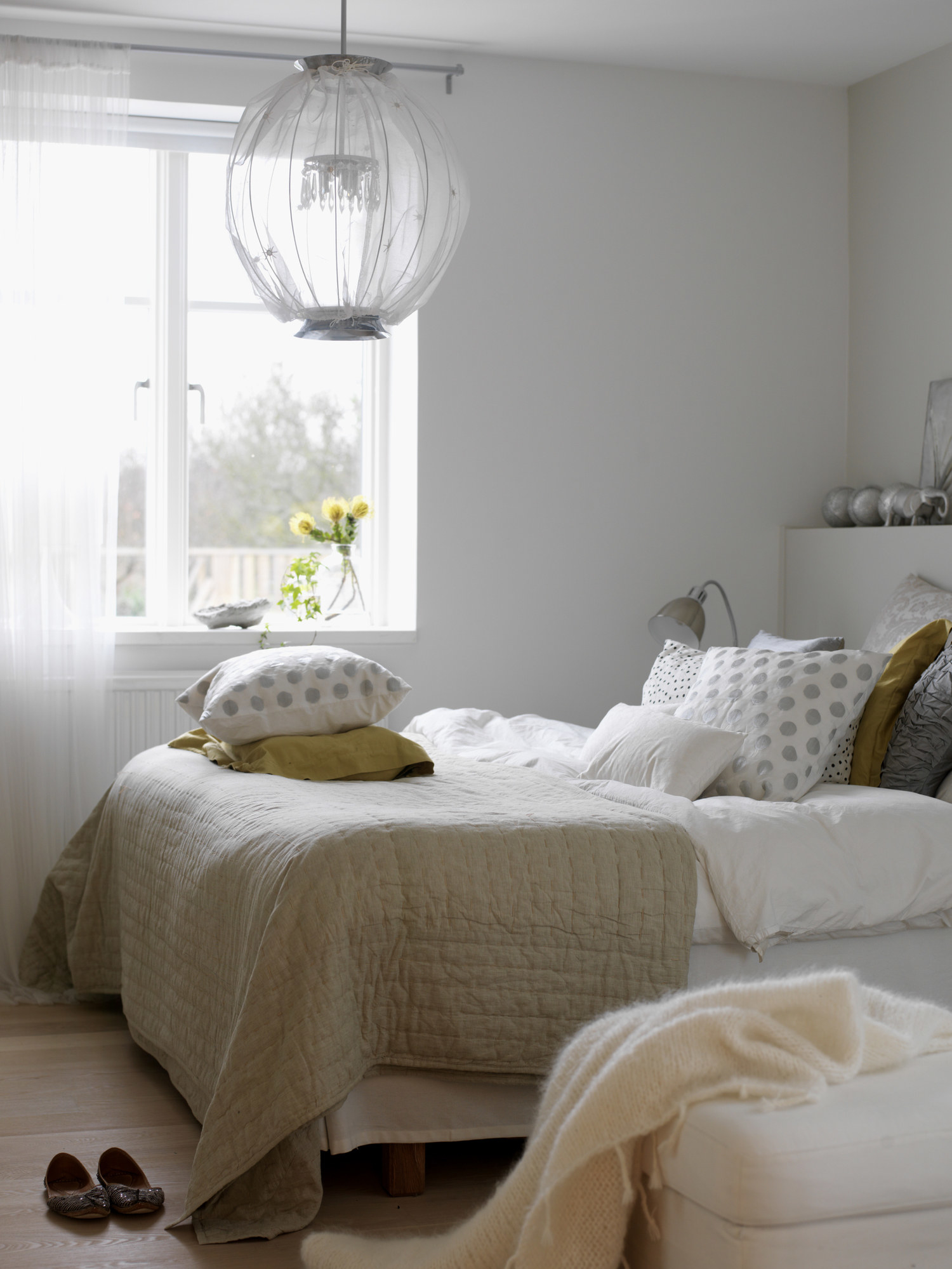 A bed with a mountain of pillows on top of it