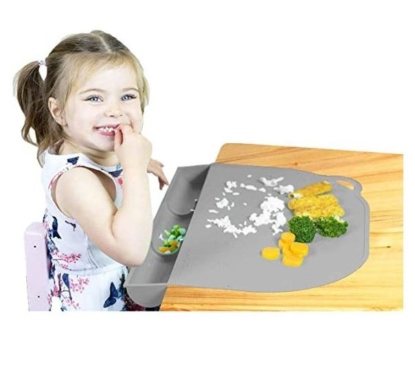 Little girl eating off place mat