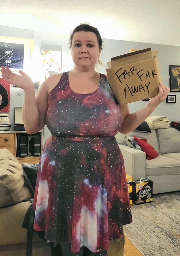 Woman in a celestial dress and holding a box with &quot;far, far away&quot; written on it