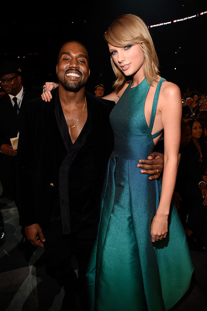 Kanye West wears a dark suit and Taylor Swift wears a sleeveless gown