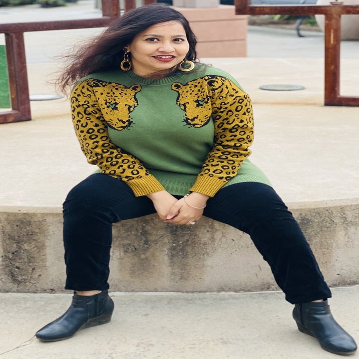 a reviewer wearing the leopard sweater in green and mustard