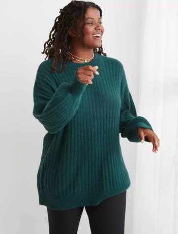 a model in a dark green sweater