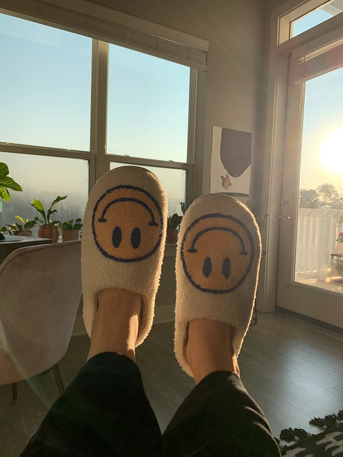 a reviewer wearing fuzzy white slippers with smiley faces on each one
