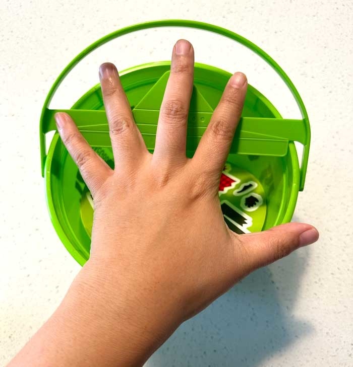 My hand extending past the edges of the bucket