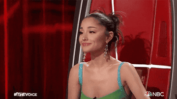 Ariana Grande on The Voice holding up her hand