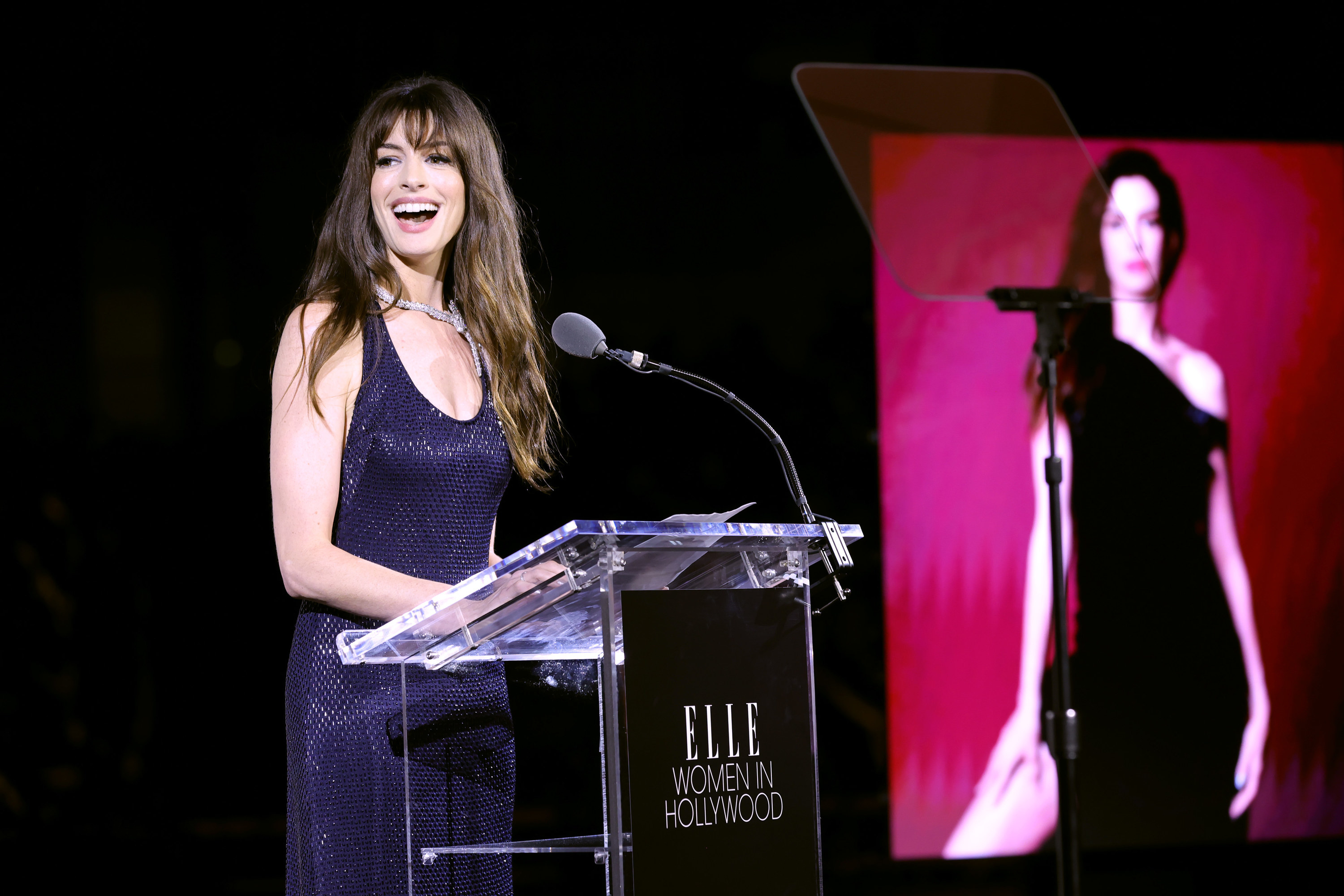 Anne stands in front of a podium on stage