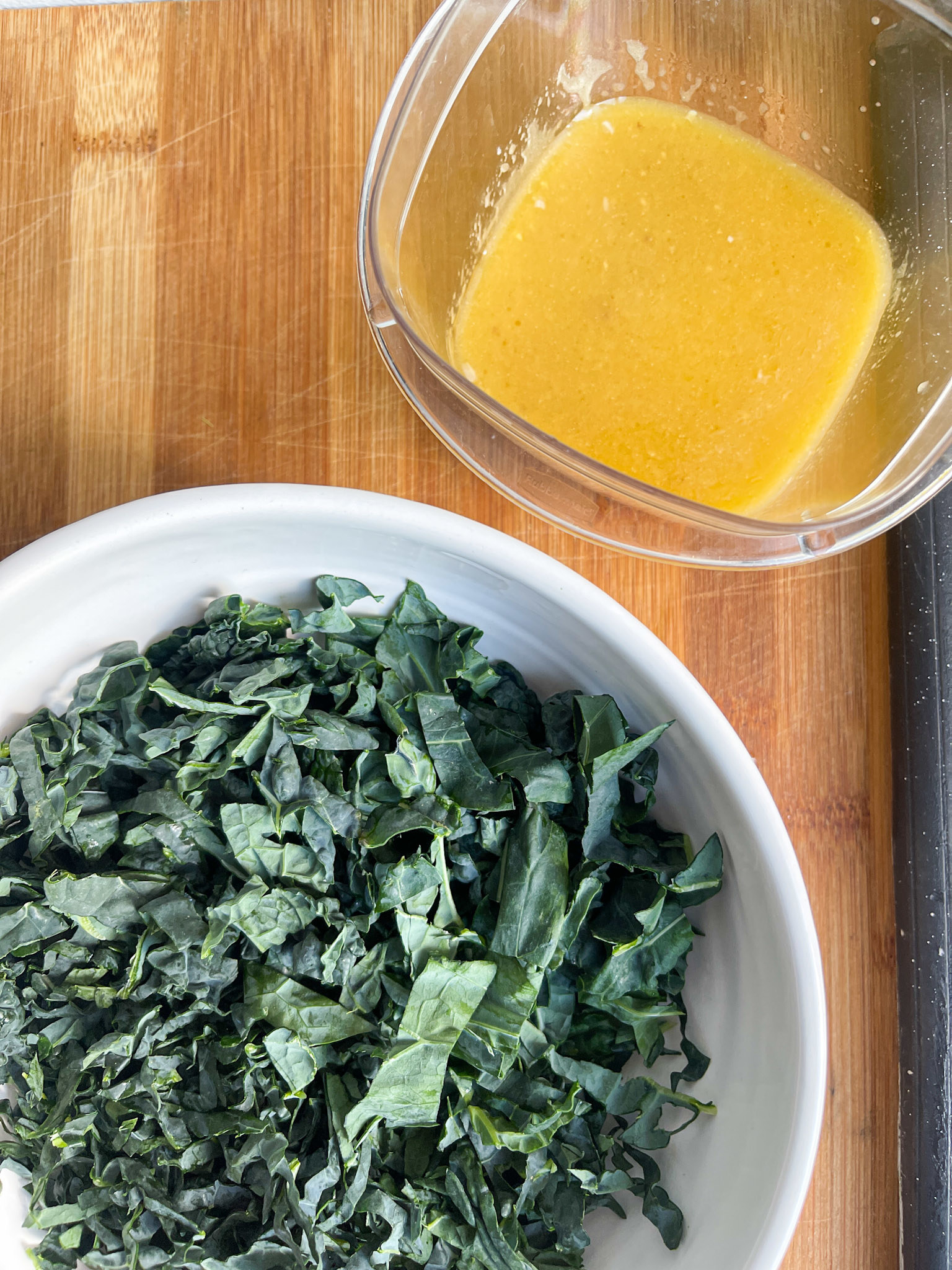 kale in a bowl next to salad dressing