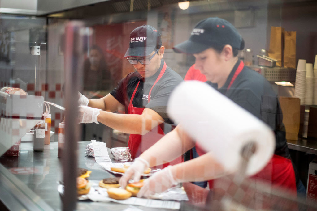 Five Guys employees assembling burgers.
