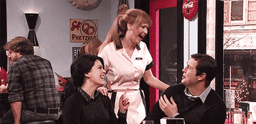 A waitress and two diners laughing.
