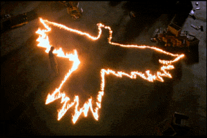 man stands above a burning crow symbol in the ground