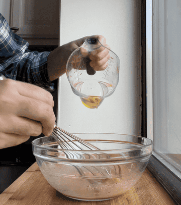 pouring olive oil slowly into bowl for whisking