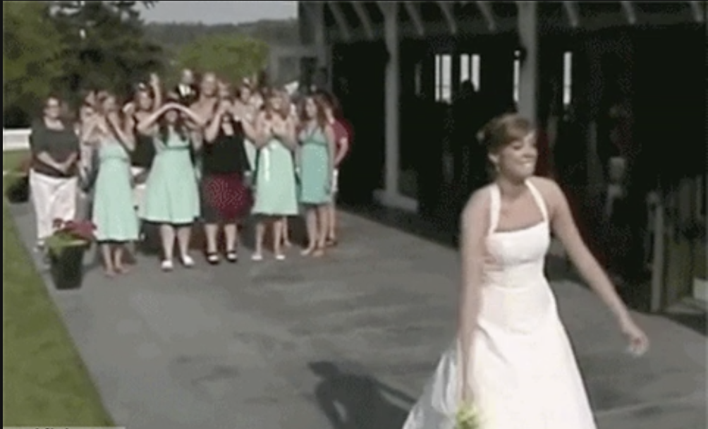 a bride throwing her bouquet into a crowd of women