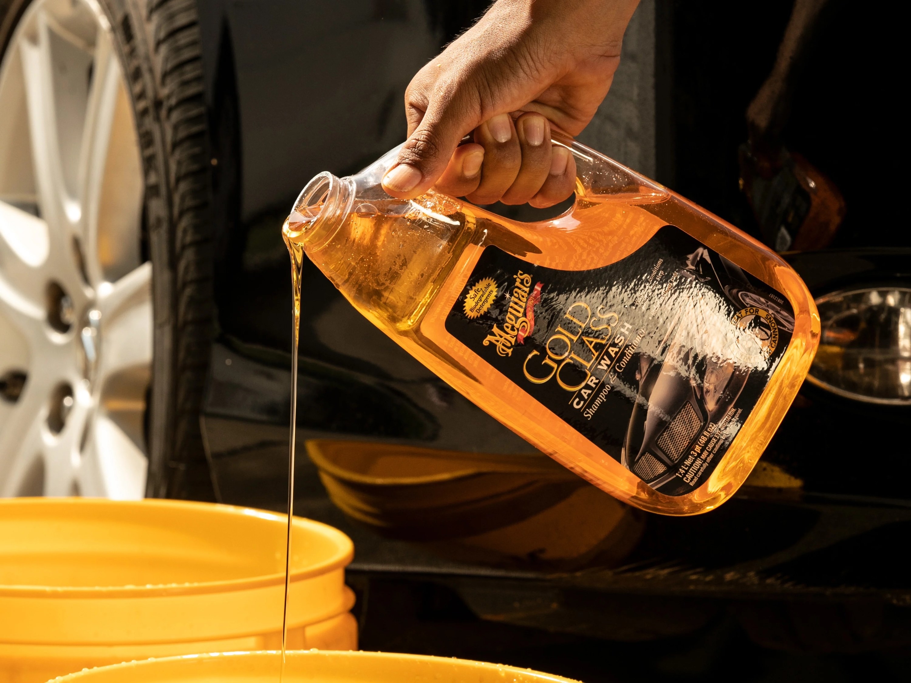 A model pouring yellow product in a yellow tub