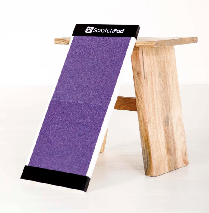 Purple scratch pad leaning against a wooden stool