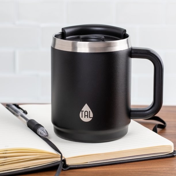 A black mug on top of a notebook
