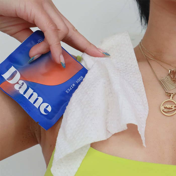 a person holding the pack of cleansing wipes