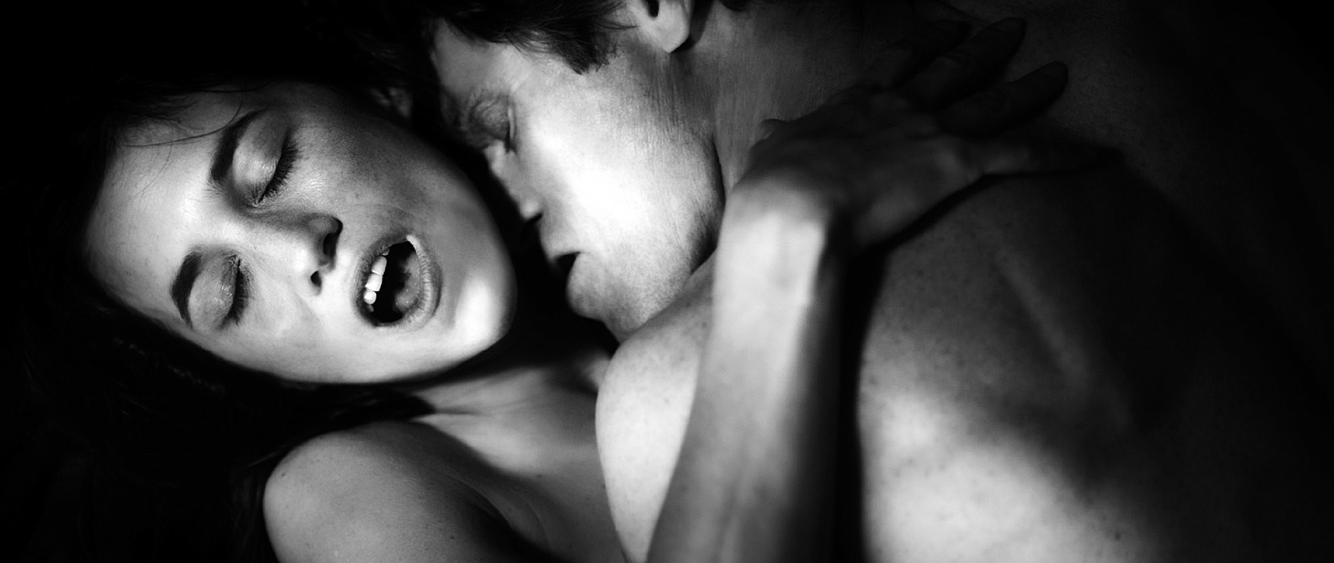 Black-and-white image of two people embracing passionately