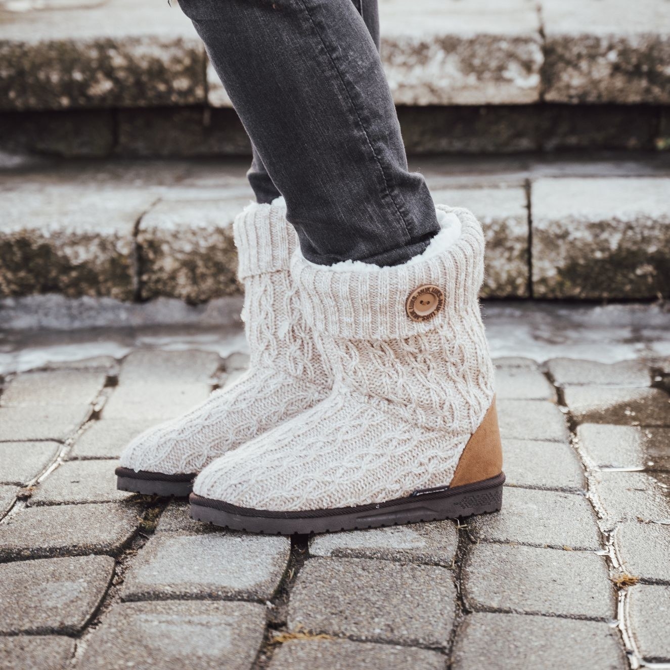 model wearing a pair of beige/brown knitted boots