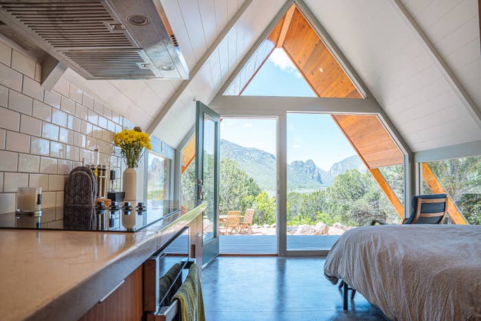 The interior of an A-frame home that looks out at mountains