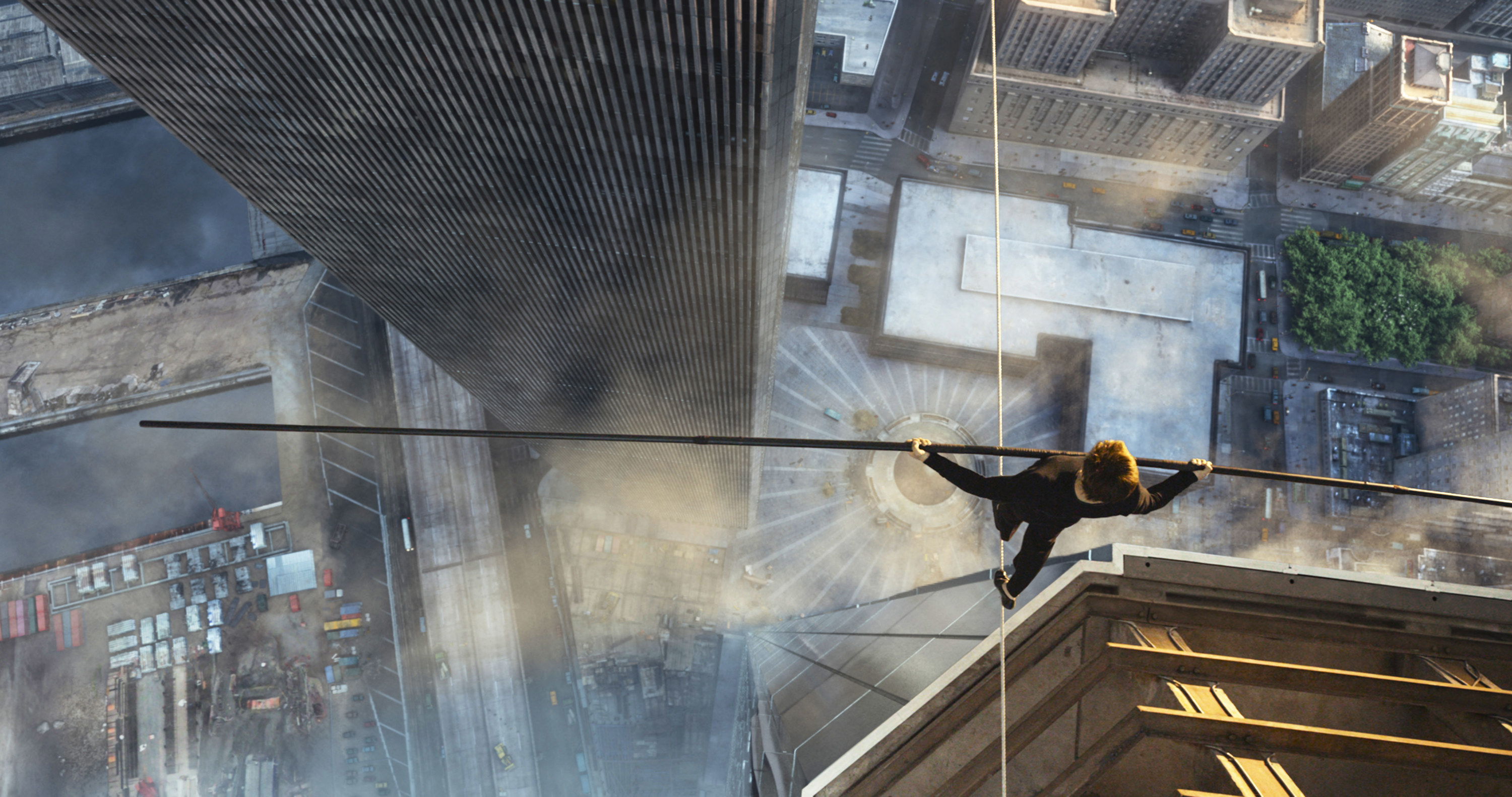 A man walks on a tight rope above a city