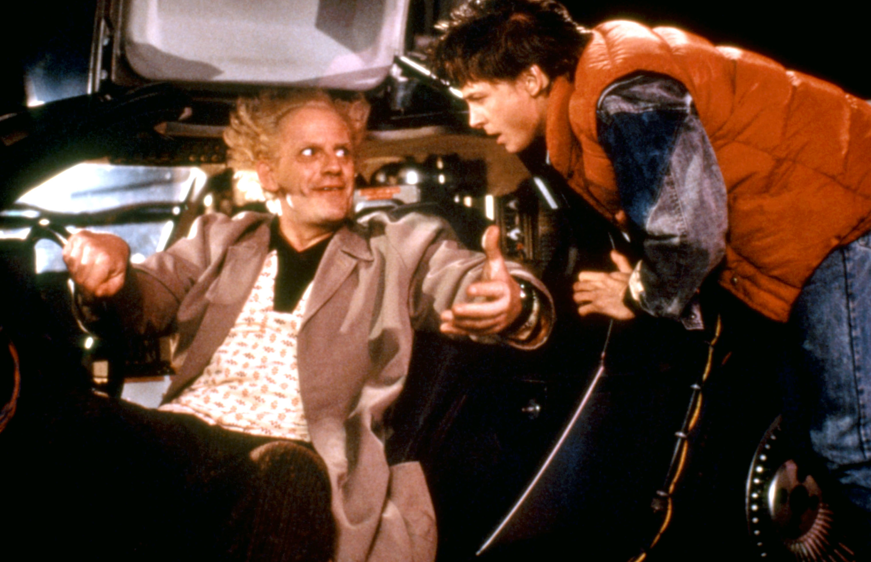 Dr Emmett Brown in the driver&#x27;s seat and Marty McFly leaning over him