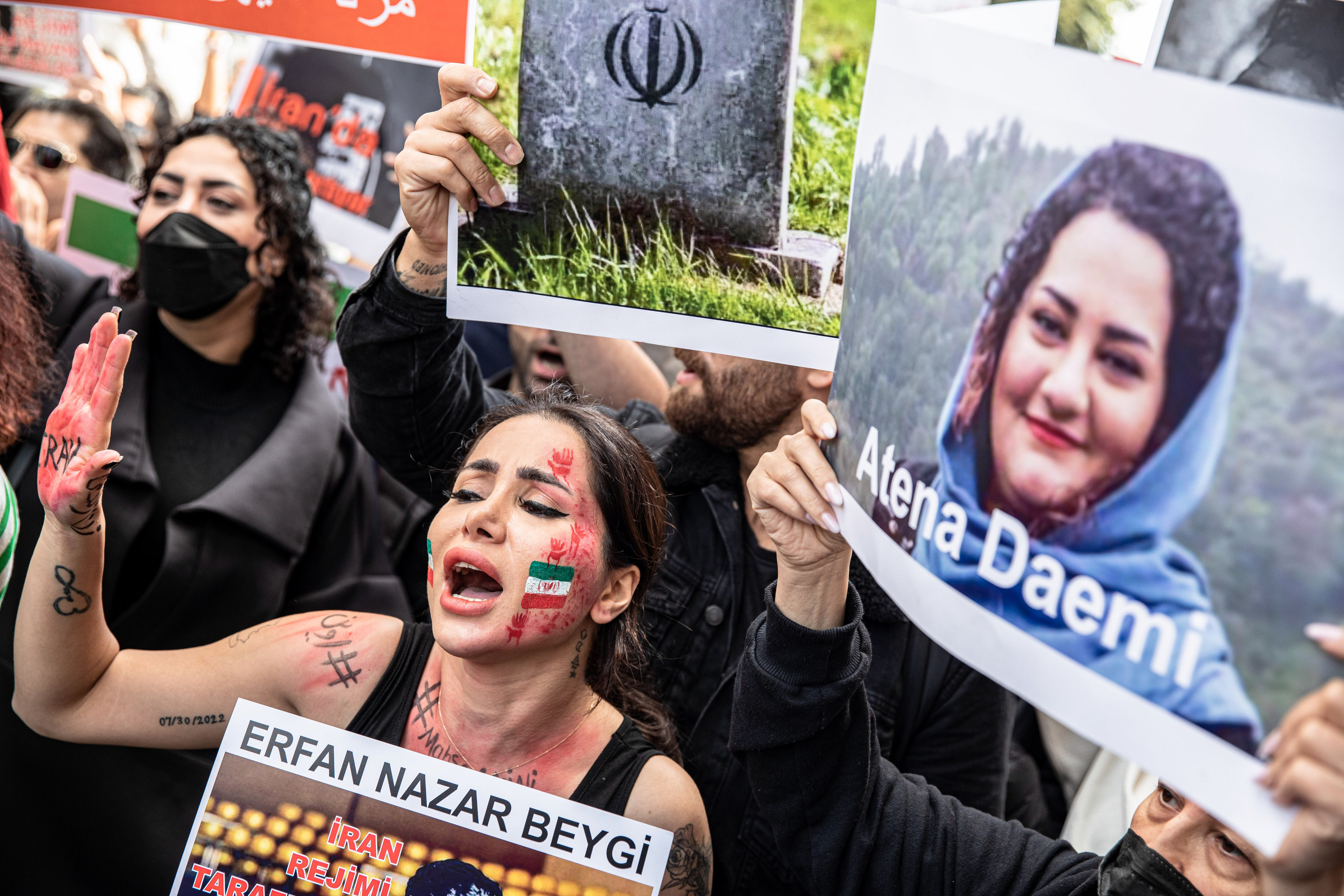 A protester in Turkey with the Iranian flag painted on her face chants slogans outside the Iranian consulate in Istanbul during a protest over the death of Iranian Mahsa Amini