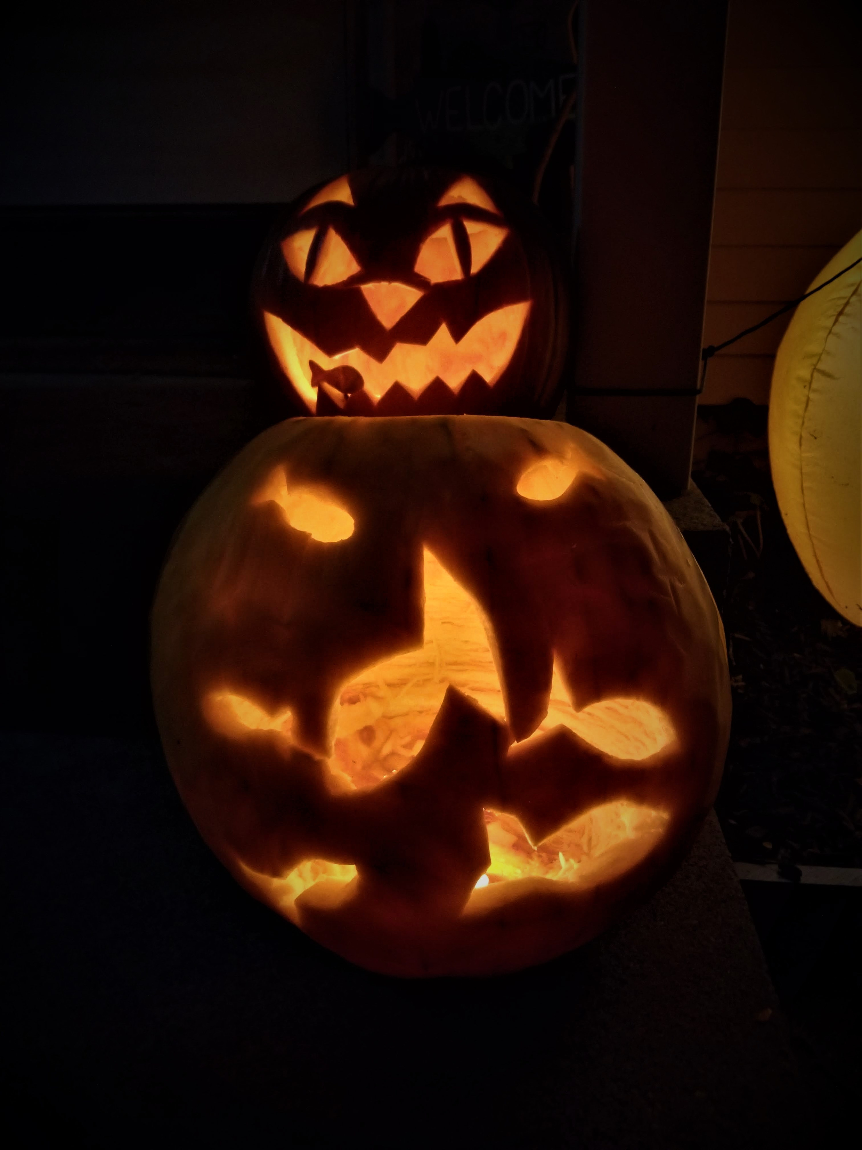 Hand carved pumpkin of a cat eating a fish and a fishbowl