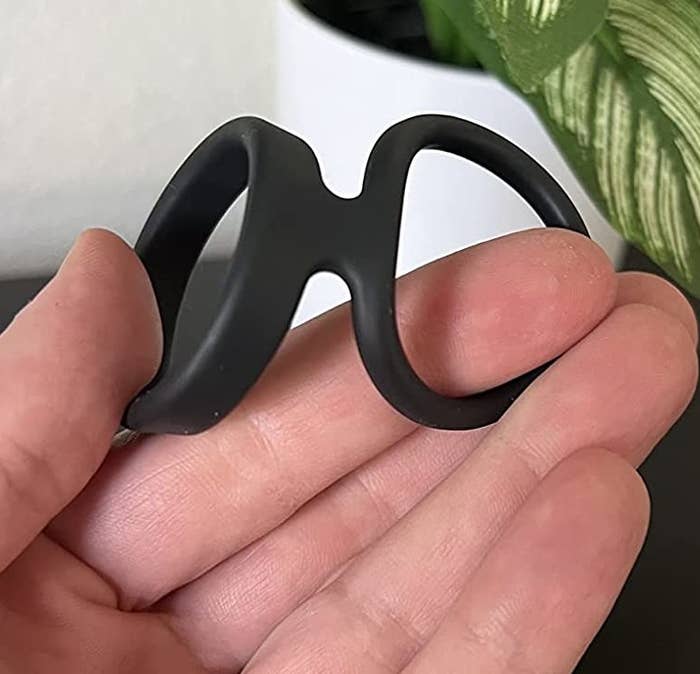 Reviewer stretching black dual cock ring