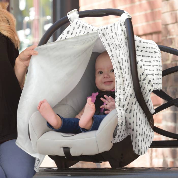 Car seat cover on car seat with baby in it