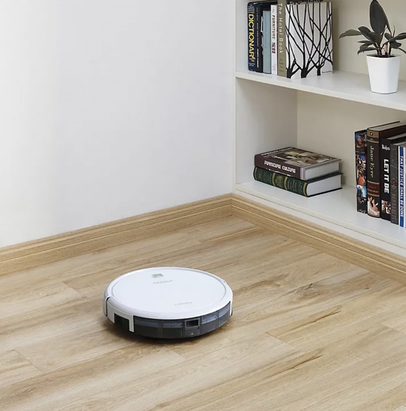 the white robot vacuum cleaning a hardwood floor