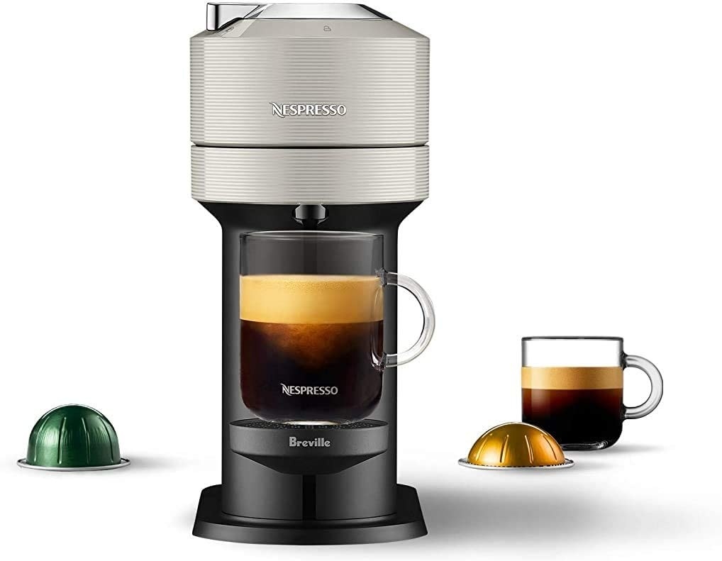 a nespresso machine and some pods against a plain background