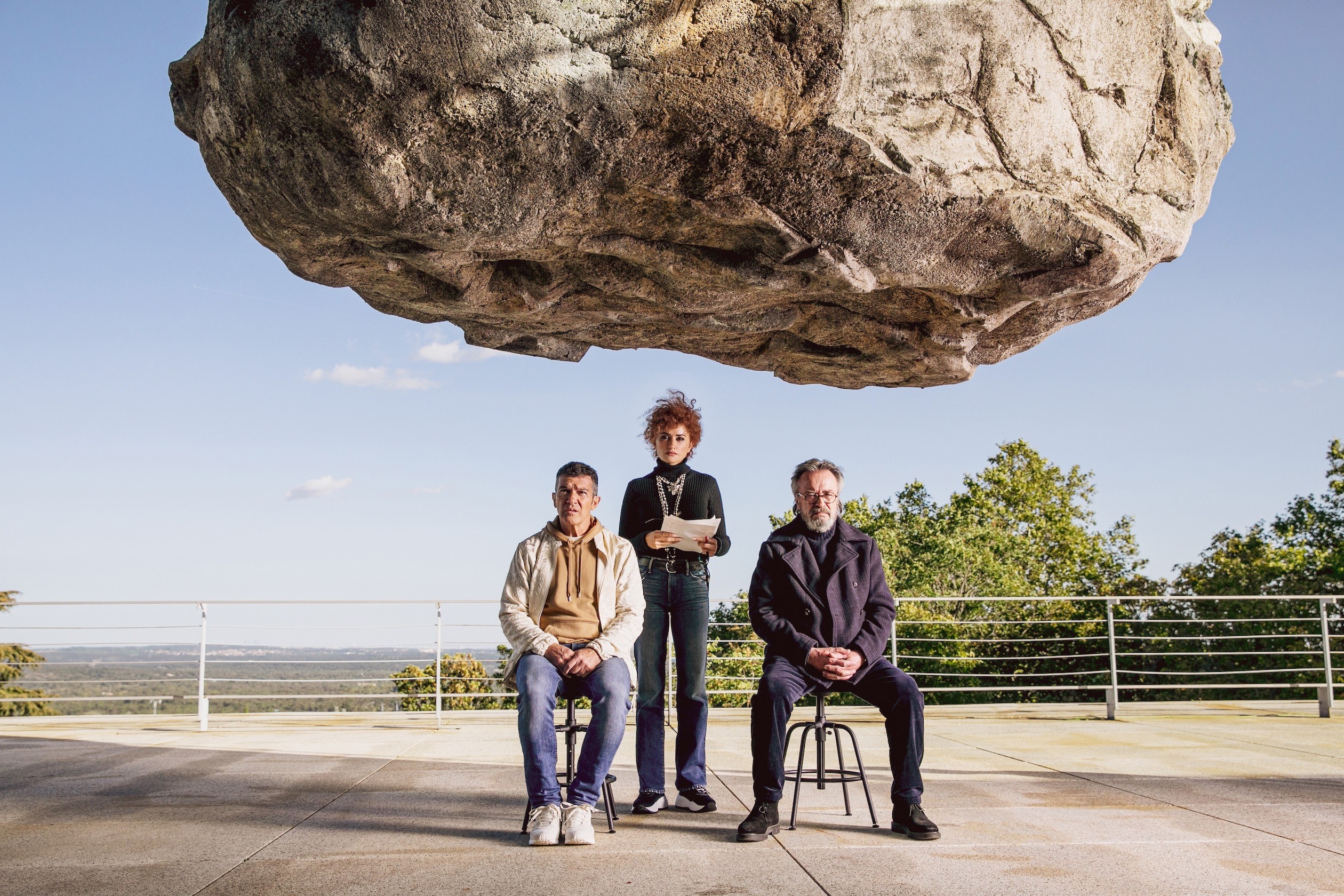 Antonio Banderas, Penelope Cruz, and Oscar Martinez sit under a giant rock