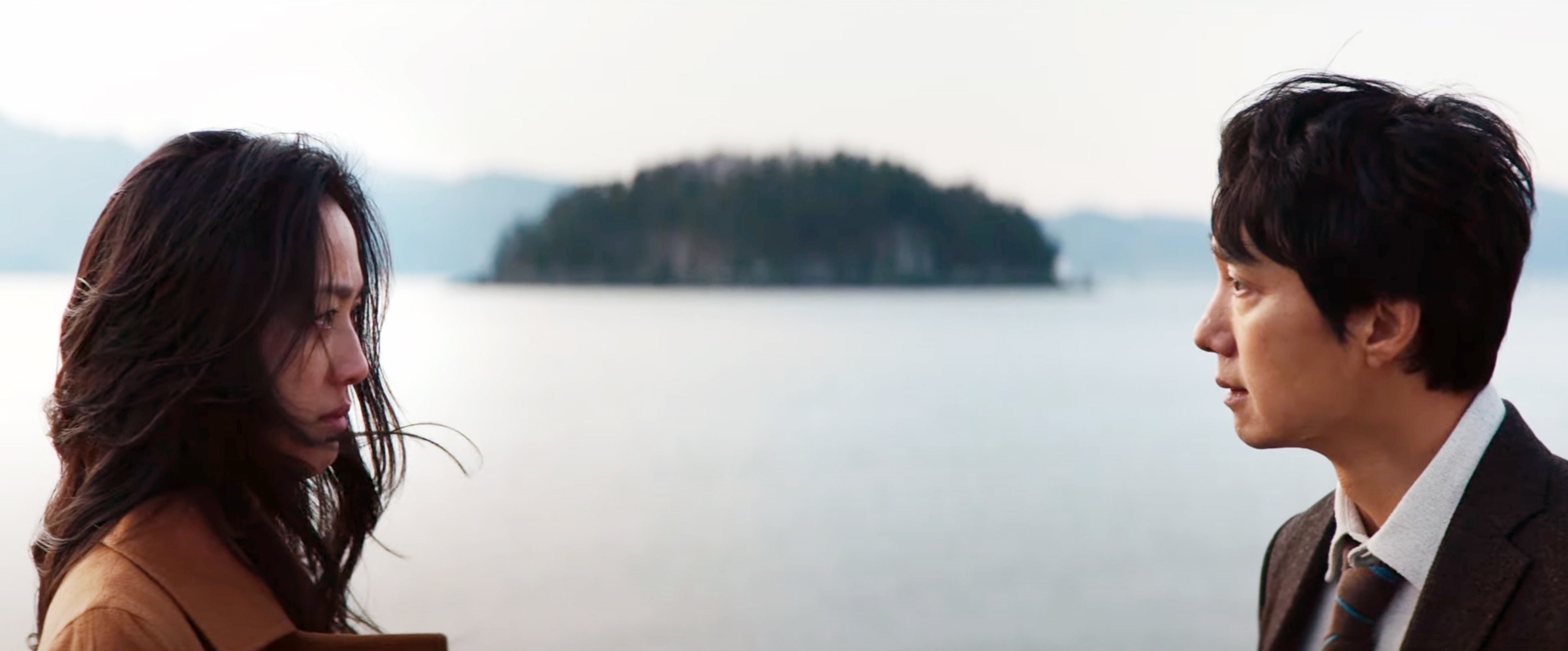 Tang Wei and Park Hae-il look at each other by the water