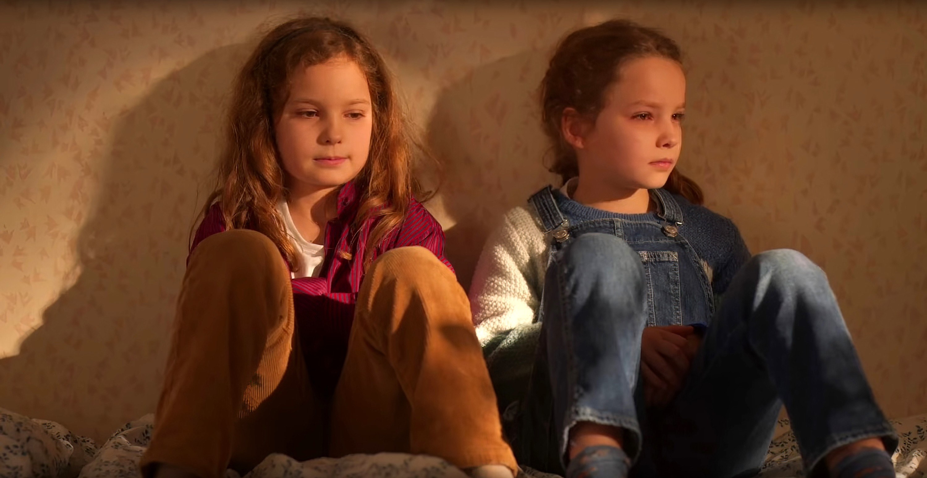 Josephine Sanz and Gabrielle Sanz sit up against a wall