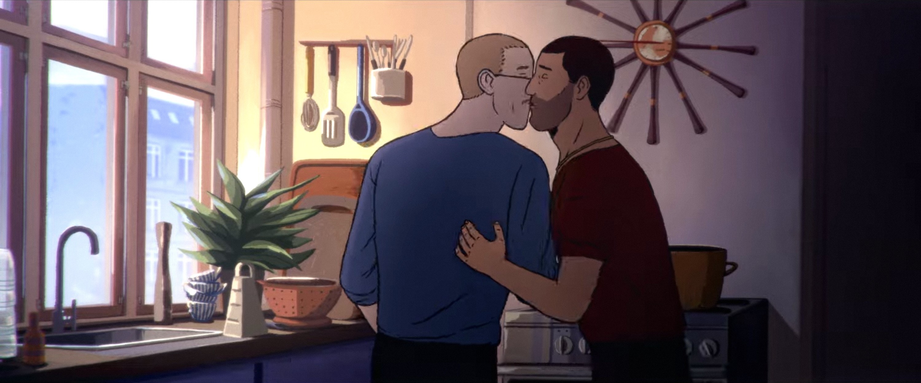 Two men kiss in a kitchen