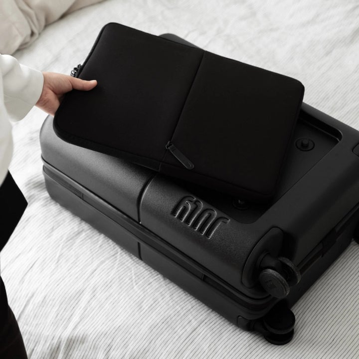 Laptop case being placed back in it's compartment on the suitcase